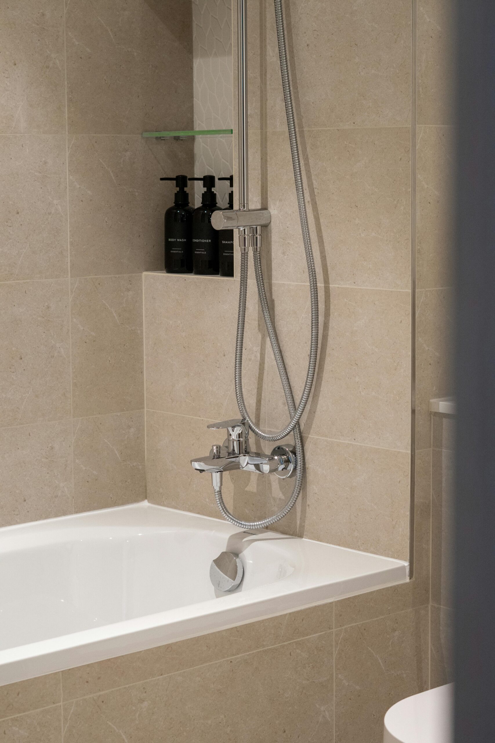 image-1 Finished beige porcelain tile flooring and tub surround in a remodeled Cincinnati bathroom.